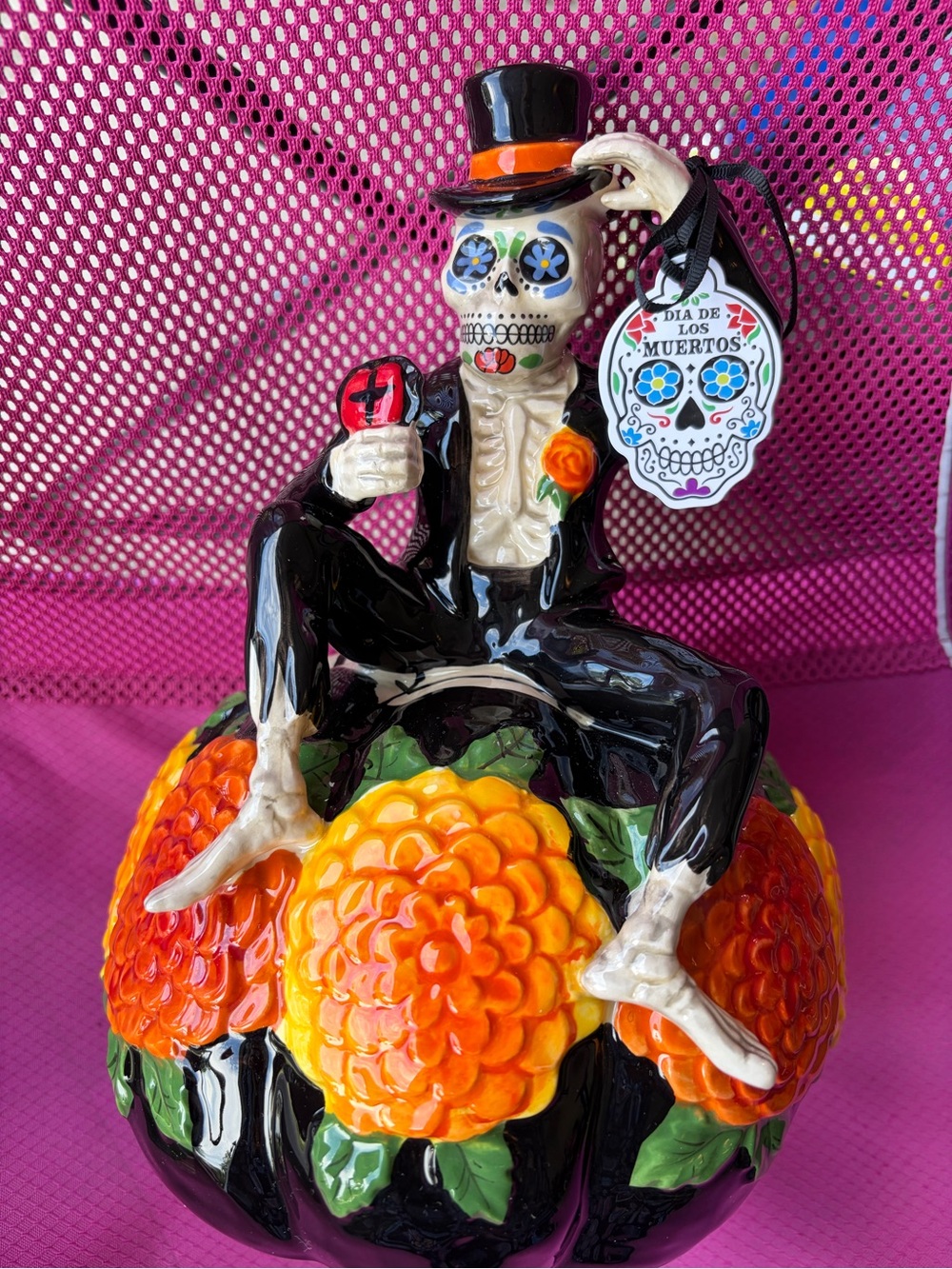 Day of the Dead skeleton with top hat sitting in a pumpkin from blue sky